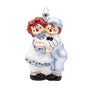 Glass Raggedy Ann & Andy Holiday Hug ornament featuring the classic dolls hugging face to face in blue and white outfits.
