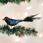 Decorative Raven bird ornament on a Christmas tree branch with lights in the background