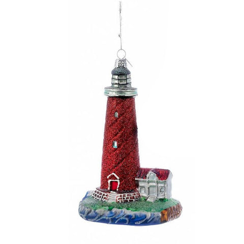 Red lighthouse by the sea ornament with glittered red tower, small coastal cottage, ocean wave base, and silver hanging cord.