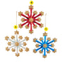 Three fireworks-style snowflake ornaments in red, white, and blue with gold glitter stars and gold hanging cords.