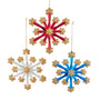 Three fireworks-style snowflake ornaments in red, white, and blue with gold glitter stars and gold hanging cords.
