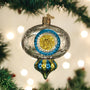 Decorative Christmas ornament with blue and gold design on a tree with lights in the background
