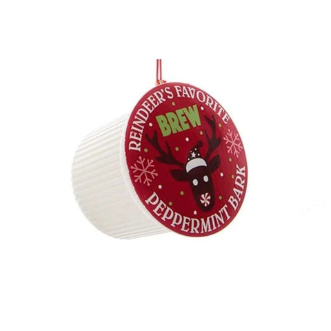 Coffee pod ornament with a red label reading “Reindeer’s Favorite Brew Peppermint Bark” and a reindeer design, hanging from a red cord.