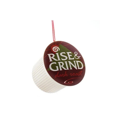 Coffee pod ornament with a brown label reading “Rise & Grind dark roast” hanging from a red cord.
