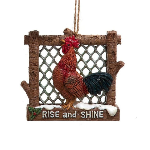 Rooster ornament in a rustic fence-style frame with snowy accents and the phrase “Rise and Shine” on the bottom.