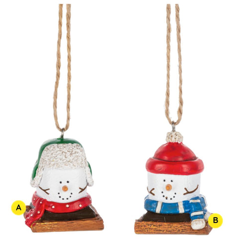 Two S’more Wintertime ornaments shown together, each featuring a marshmallow snowman-style figure on a graham cracker base dressed for winter, with one wearing a green trapper hat and red scarf and the other wearing a red hat and blue scarf.