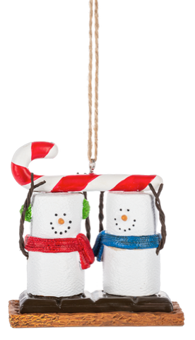S’mores Candy Cane ornament featuring two marshmallow snowman-style figures with twig arms and colorful scarves, standing on a graham cracker base beneath a red and white candy cane.