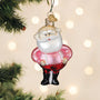 Glass Santa Claus ornament hanging on a Christmas tree with blurred lights in the background