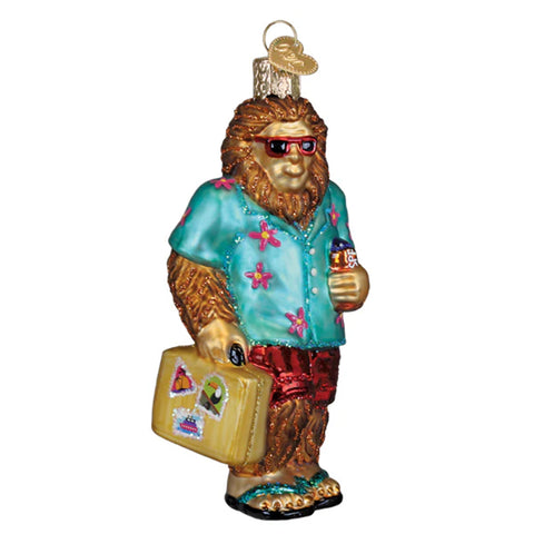 Decorative ornament of a Sasquatch in summer attire with sunglasses, shirt, shorts, and suitcase.