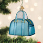 Blue handbag ornament hanging on a Christmas tree with blurred lights in the background