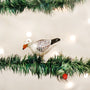 Decorative seagull ornament on a Christmas tree with lights in the background