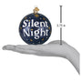 Decorative ornament with 'Silent Night' text held in a hand, showing its size.