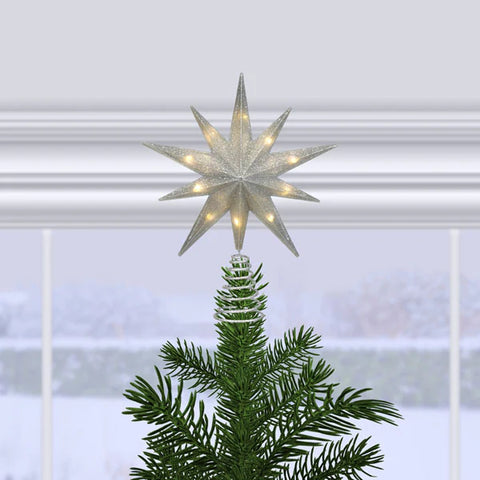 12" silver glitter star treetop lit on a Christmas tree in front of a snowy window scene.