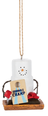 S’mores Cornhole Champ ornament featuring a marshmallow snowman with pretzel stick arms, a cornhole board that reads “Cornhole Champ,” red bean bags, and a graham cracker base.