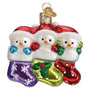 Three glass snowman ornaments in colorful stockings with Santa hats on a white background