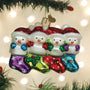Snowfamily of 4 happy snowmen peek from festive stockings on tree