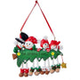 Personalized snowman family of 4 ornament with four smiling snowmen peeking over a decorated Christmas tree with dangling legs and space for a family name or short phrase and year.