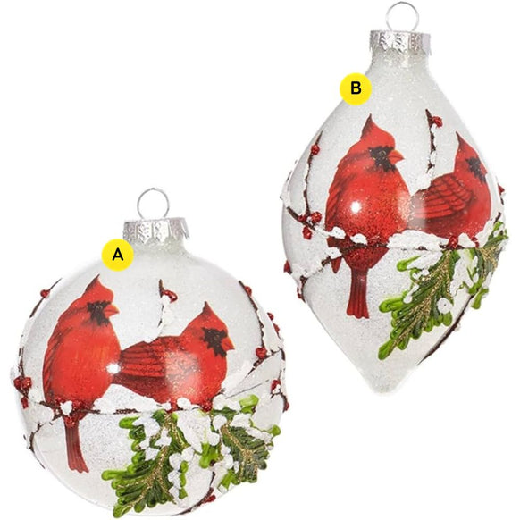 Glass ornament featuring two red cardinals perched on snow-covered branches with frosted greenery, available in round and finial shapes.