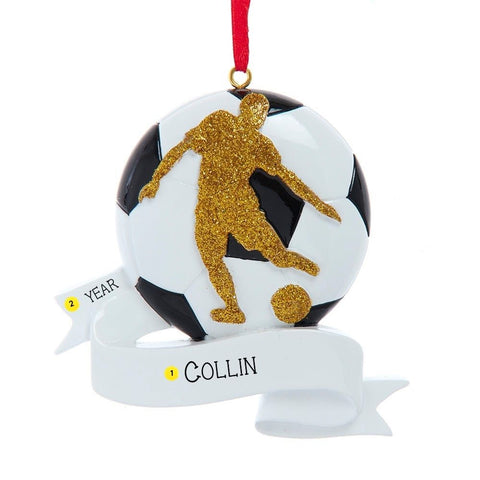 Personalized soccer ornament shaped like a black and white soccer ball with a glittered player silhouette and white banner for a name and year.