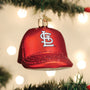 St. Louis Cardinals baseball cap shaped ornament with a logo, hanging on a Christmas tree with lights in the background.