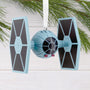 Star Wars TIE fighter ornament hanging on a branch with a white background