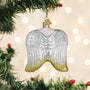 Decorative angel ornament hanging on a Christmas tree with lights in the background.