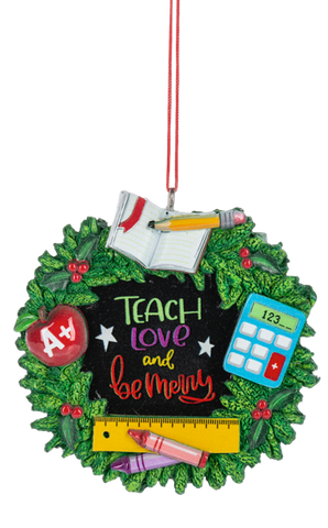 Teacher wreath ornament with green holly leaves surrounding a chalkboard-style center that reads “Teach love and be merry,” accented with an A+ apple, calculator, notebook, pencil, ruler, and crayon.