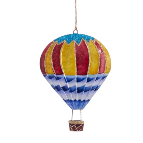 Tin hot air balloon ornament with red and yellow panels, a blue and white striped base, and a small hanging basket.