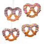 Decorative pretzels with colorful sprinkles and chocolate drizzle on a white background