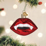 Red glass ornament shaped like Vampire lips on a Christmas tree with lights in the background