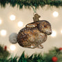 Glass Vintage Cottontail Bunny ornament hanging on a Christmas tree with lights in the background