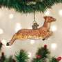 Vintage glass deer ornament hanging on a Christmas tree with lights in the background