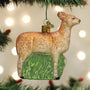 Glass deer ornament hanging on a Christmas tree with lights in the background