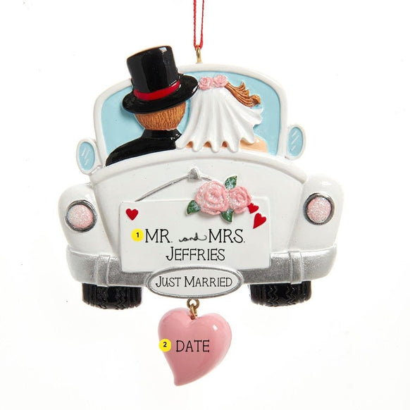 Personalized wedding car ornament featuring a bride and groom in a white getaway car, shown with Mr. and Mrs. last name personalization and a wedding date on the dangling pink heart.