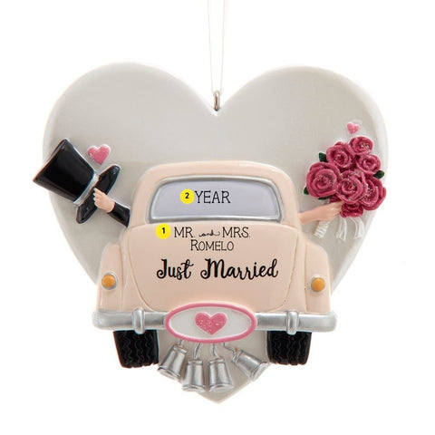 Personalized Wedding Getaway Car Heart Ornament featuring a classic just married car with wedding bells, pink roses, a heart-shaped backdrop, and sample Mr. and Mrs. last name and year personalization.