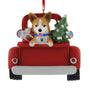 Christmas ornament with a Welsh Corgi dog in a red truck carrying a gift and a tree on a white background