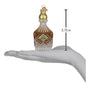 Decorative glass whiskey bottle ornament on a hand with measurement label