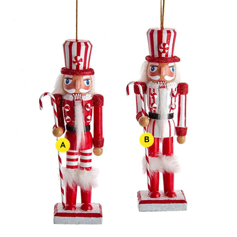 Wooden peppermint nutcracker ornaments in two red and white styles with striped hats, candy cane staffs, glittered accents, and fluffy trim.