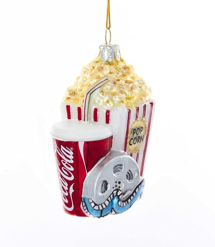 Glass ornament featuring a red Coca-Cola cup, striped popcorn container, and silver film reel grouped together in a movie-themed design.