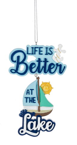 Life Is Better at the Lake ornament with blue layered lettering, a small sailboat, sun detail, and hanging string.