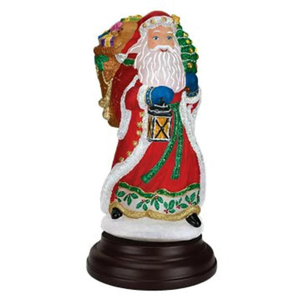 Radiant Santa Light featuring Santa in a red robe holding a lantern and carrying a toy-filled pack on a dark base