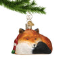 Glass Sleepy Fox Ornament hanging by a gold swirl hook from a Christmas Tree Branch