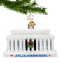 Glass Lincoln Memorial Ornament with Christmas Wreath hanging by a gold swirl hook from a Christmas tree branch