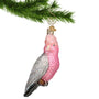 Pink Glass Cockatoo Bird Ornament hanging by a gold swirl hook from a Christmas tree branch