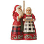 Jim Shore Santa and Mrs. Claus Ornament with santa holding a glass of milk and looking at mrs. claus holding a plate of cookies 