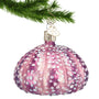 Purple sea urchin ornament hanging by a gold swirl hook