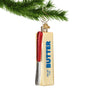 Stick of Butter Ornament with knife on top hanging from a gold swirl hook on a Christmas branch